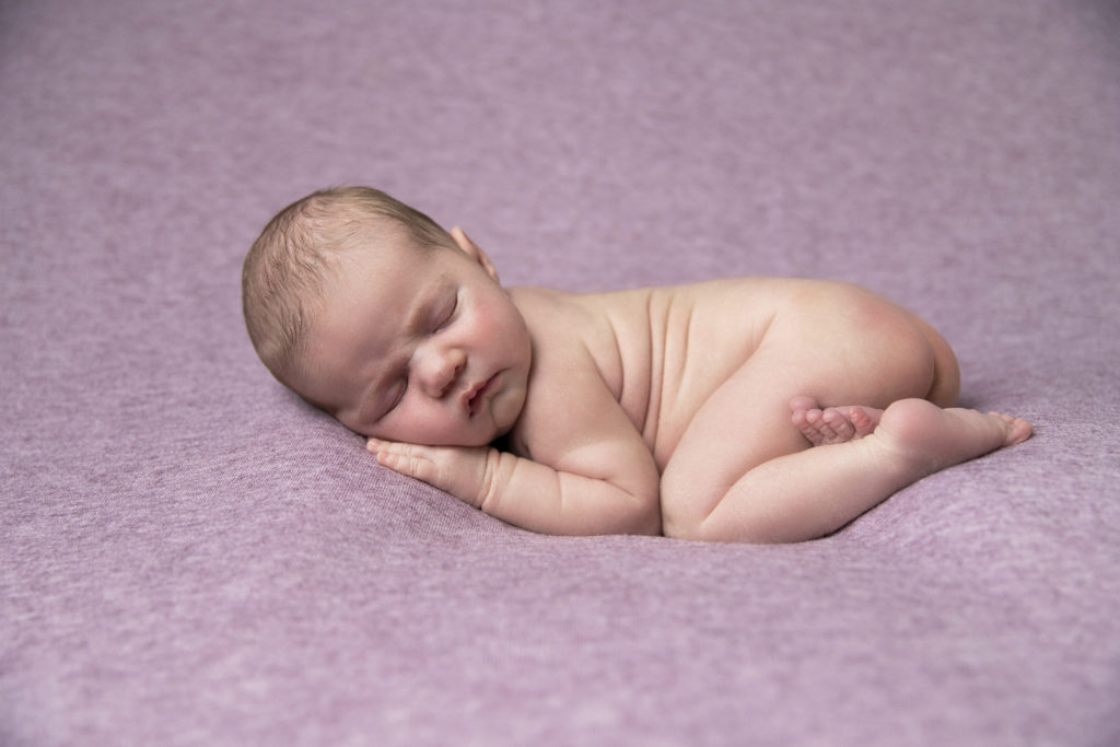 Un bébé endormi lors d'une séance photo nouveau-né, réalisée par Bérengère Grassin du studio Bérengère, photographe professionnelle.