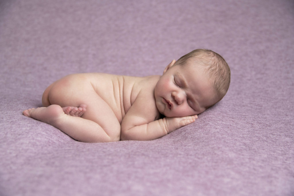 Un bébé endormi lors d'une séance photo nouveau-né, réalisée par Bérengère Grassin du studio Bérengère, photographe professionnelle.