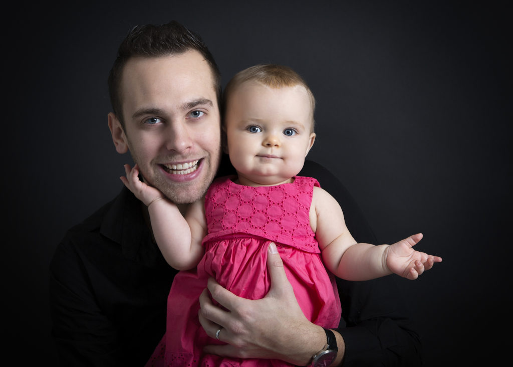 Séance photo d'un papa avec sa petite fille dans une belle robe rose.