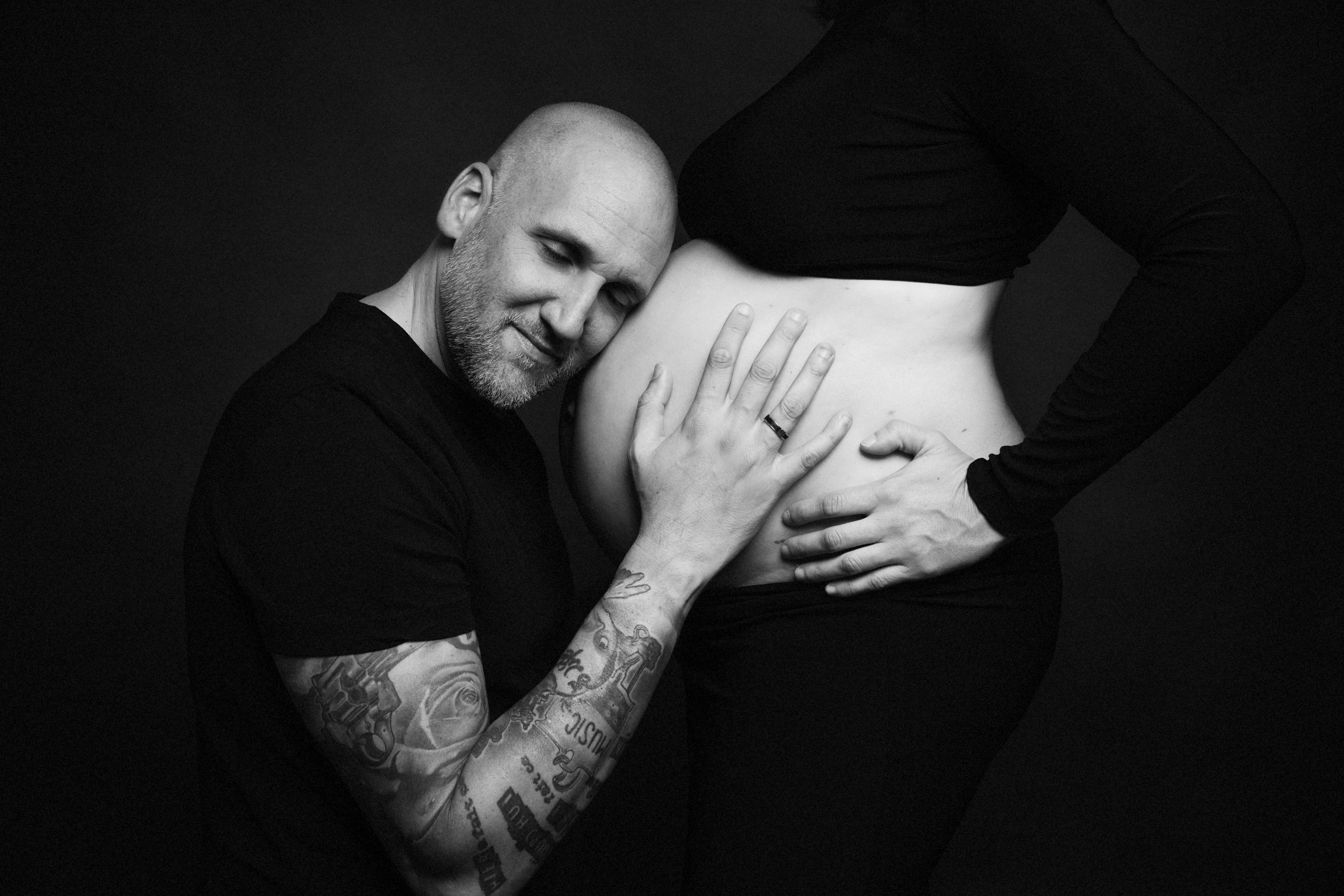 Femme enceinte et son mari, posant lors d'une séance photo grossesse, réalisée au studio Bérengère, photographe professionnelle dans les Yvelines.