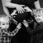 Deux enfants touchant le ventre de leur maman enceinte, posant lors d'une séance photo grossesse, réalisée par Béregère Grassin du studio Bérengère, votre photographe professionnelle dans les Yvelines.