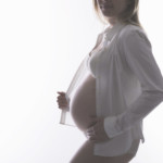 Femme enceinte de profil pour une séance grossesse.
