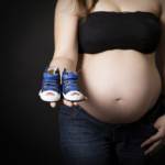 Zoom sur le ventre d'une femme enceinte, posant lors d'une séance photo grossesse, réalisée au studio Bérengère, photographe professionnelle dans les Yvelines.