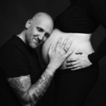 Femme enceinte et son mari, posant lors d'une séance photo grossesse, réalisée au studio Bérengère, photographe professionnelle dans les Yvelines.