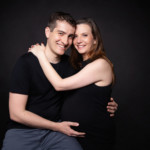Femme enceinte et son mari posant lors d'une séance photo grossesse, réalisée au studio Bérengère, photographe professionnelle dans les Yvelines.